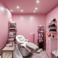 An interior layout of a cozy, small beauty parlor featuring a hair washing station, an eyebrow threading chair, a facial treatment bed and beautifully-arranged racks of beauty products.