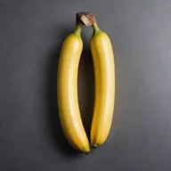 A ripe banana completely covered in a thin, glossy layer of radiant gold.