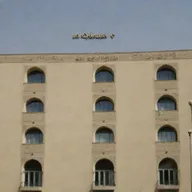 Beige buildings of a university in Tehran, with 'Taha' written in elegant Persian script overlay.