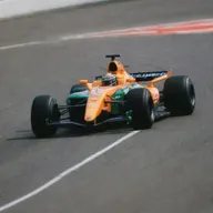 A 2000s Formula 1 car showcasing iconic design, prominent logos, and racing-related modifications.