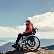 Man on a wheelchair seeated on top of a mountain